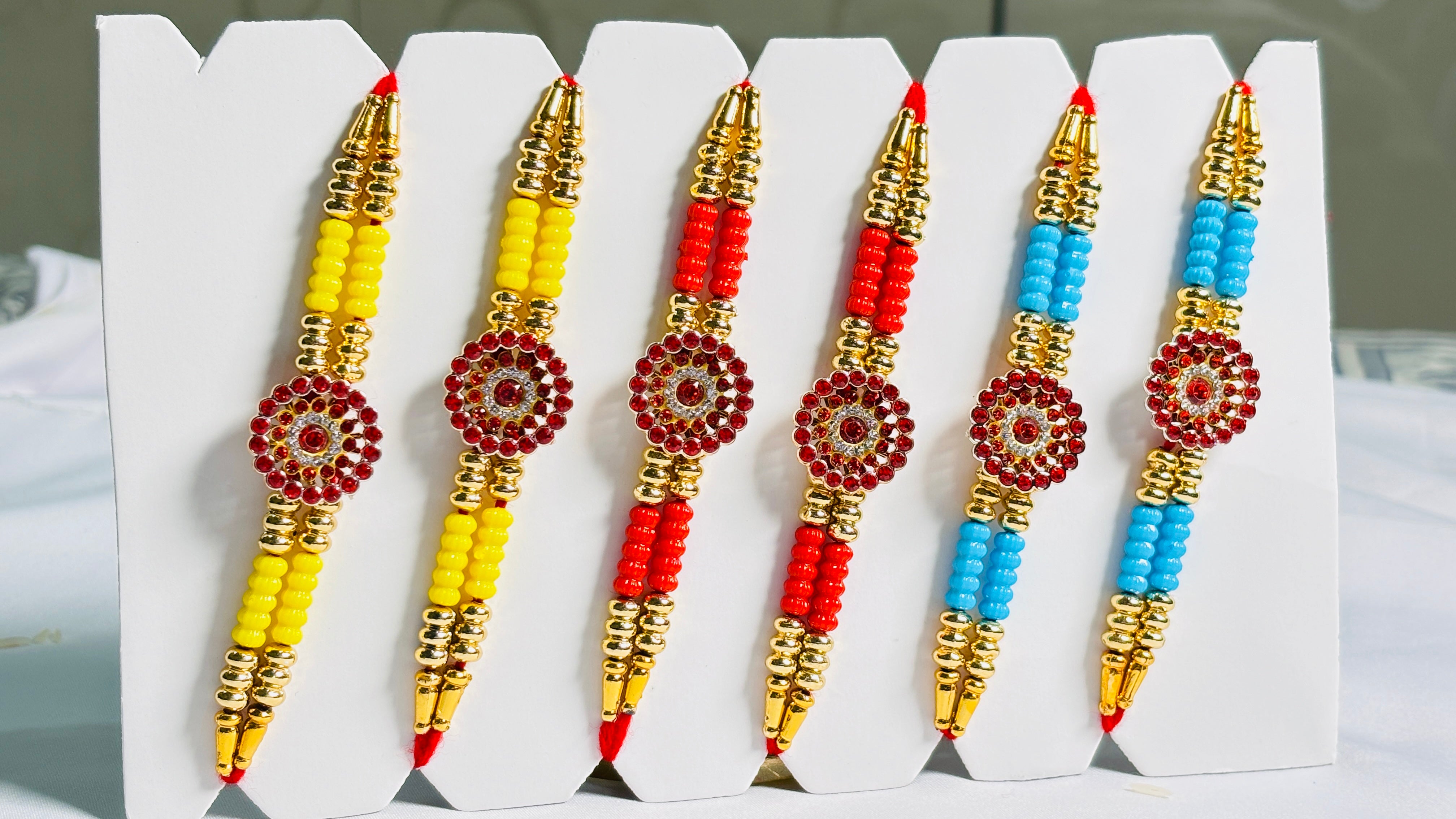 Premium Designer Rakhi Set of 12 for Brother featuring fancy handmade traditional and modern rakhi designs with decorative beads and silk threads.