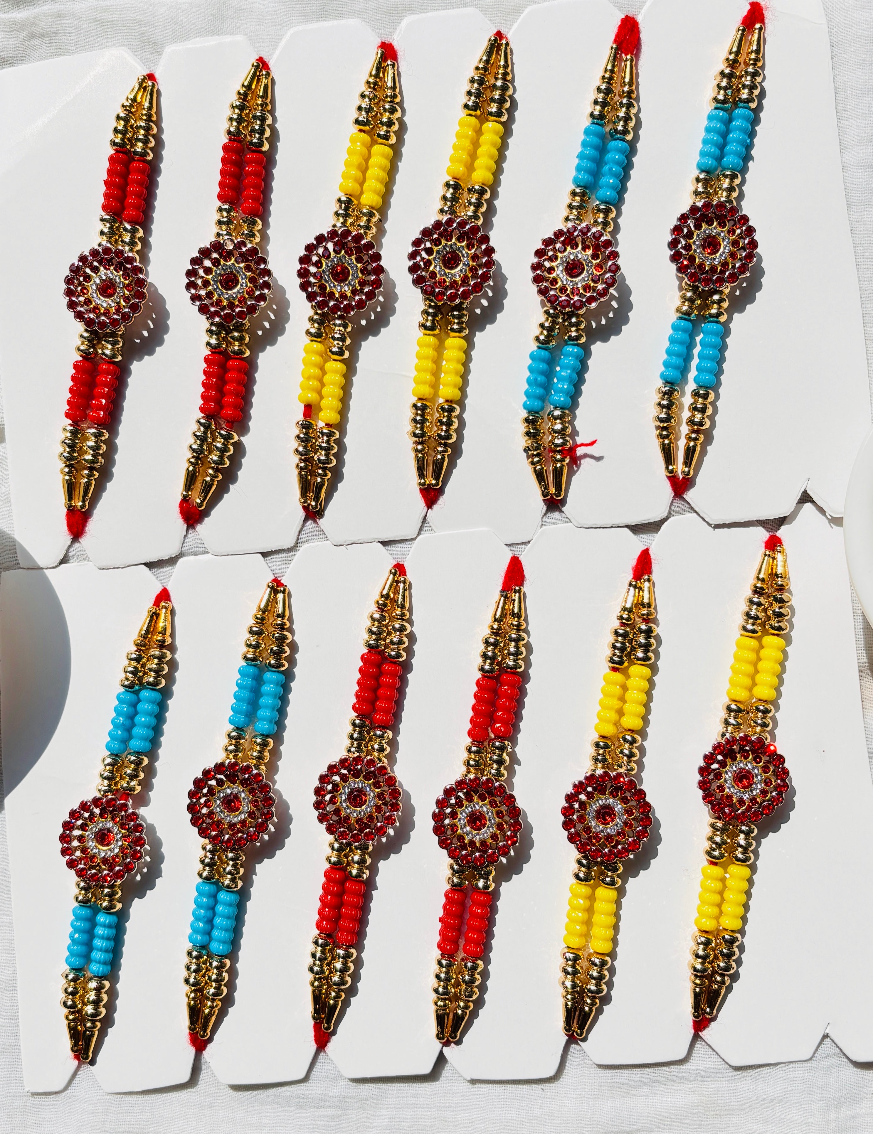 Premium Designer Rakhi Set of 12 for Brother featuring fancy handmade traditional and modern rakhi designs with decorative beads and silk threads.